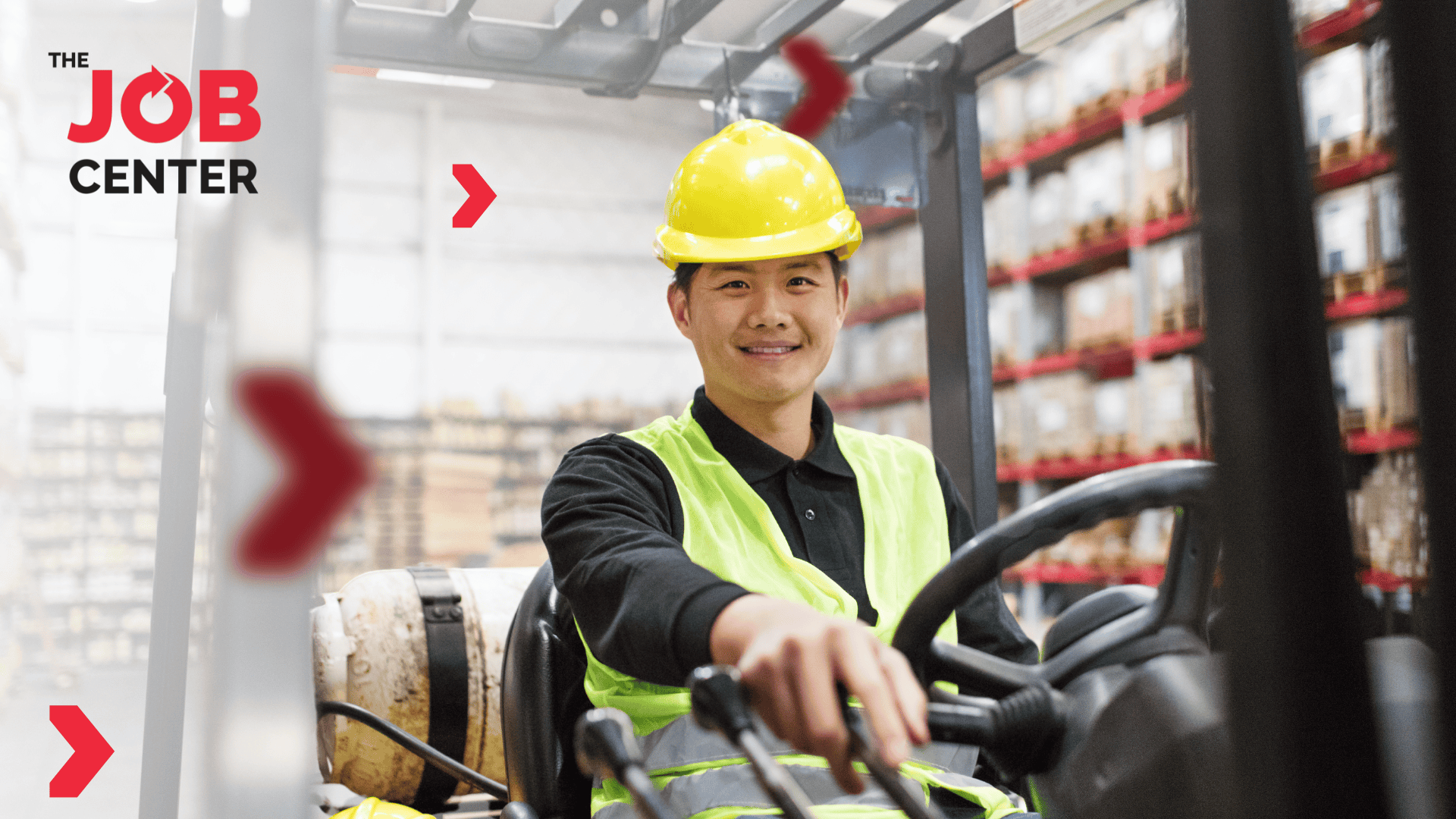 Warehouse worker in hard hat and safety vest operates forklift
