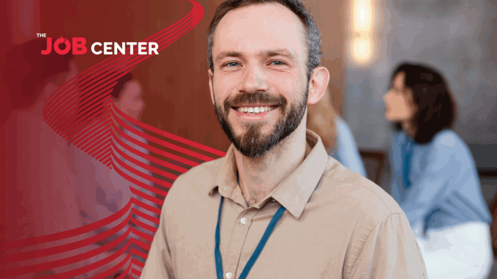 Man in corporate attire and ID strap smiles confidently